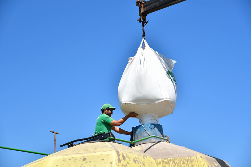 Big bag de arroz izado con grúa sobre un tractor